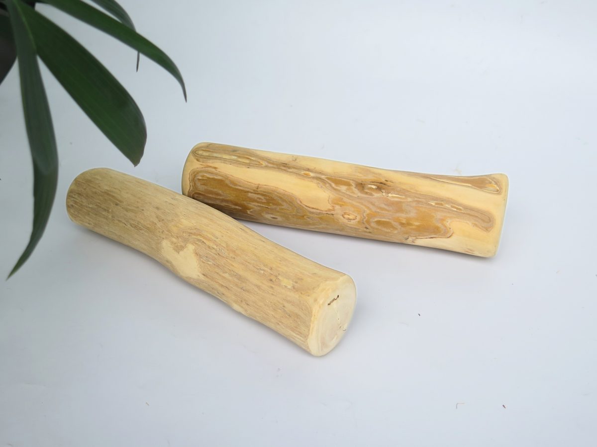 Two coffee wood dog chew sticks photographed on a white background