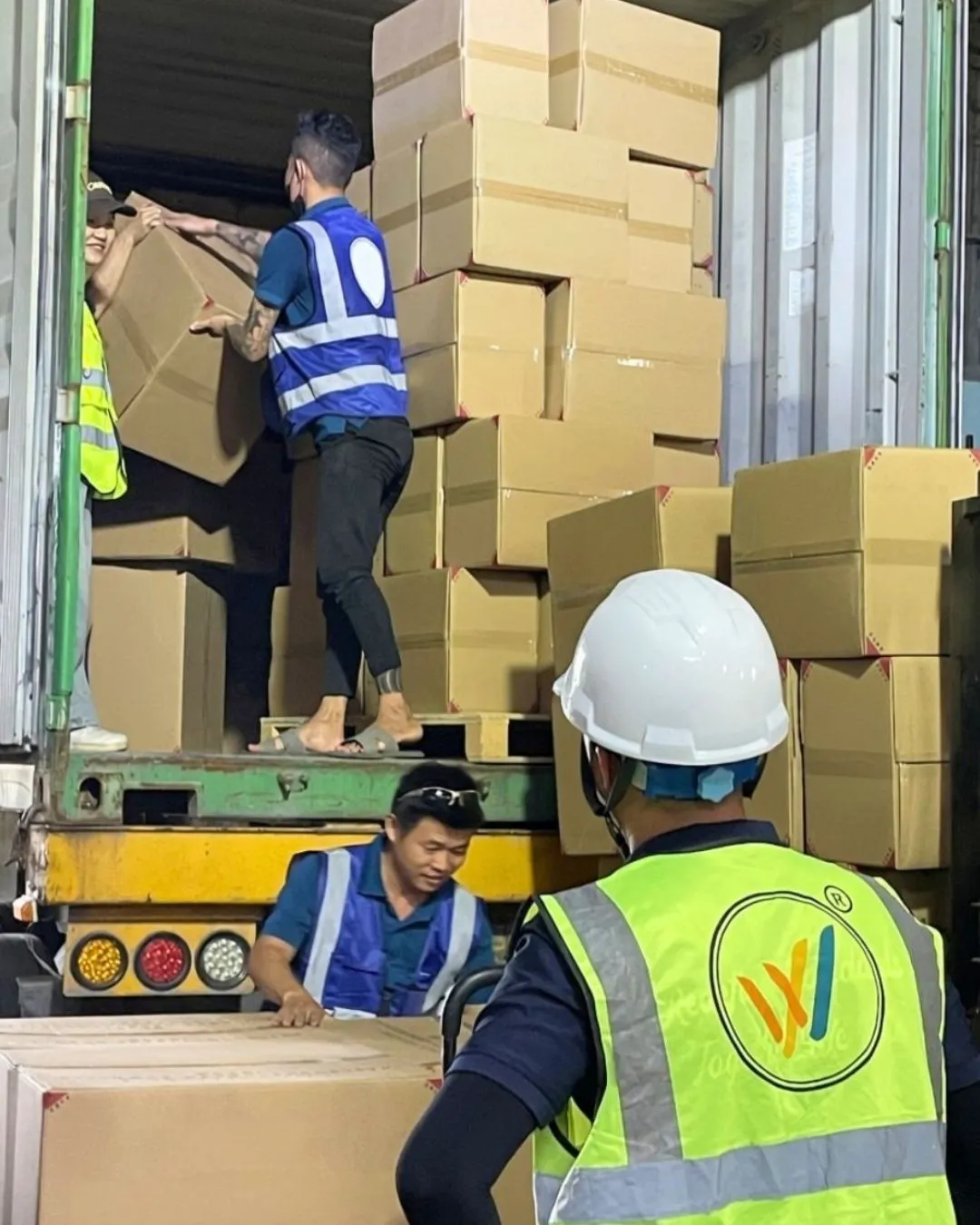 WINVN INT staff loading master cartons into a container on a tail lift
